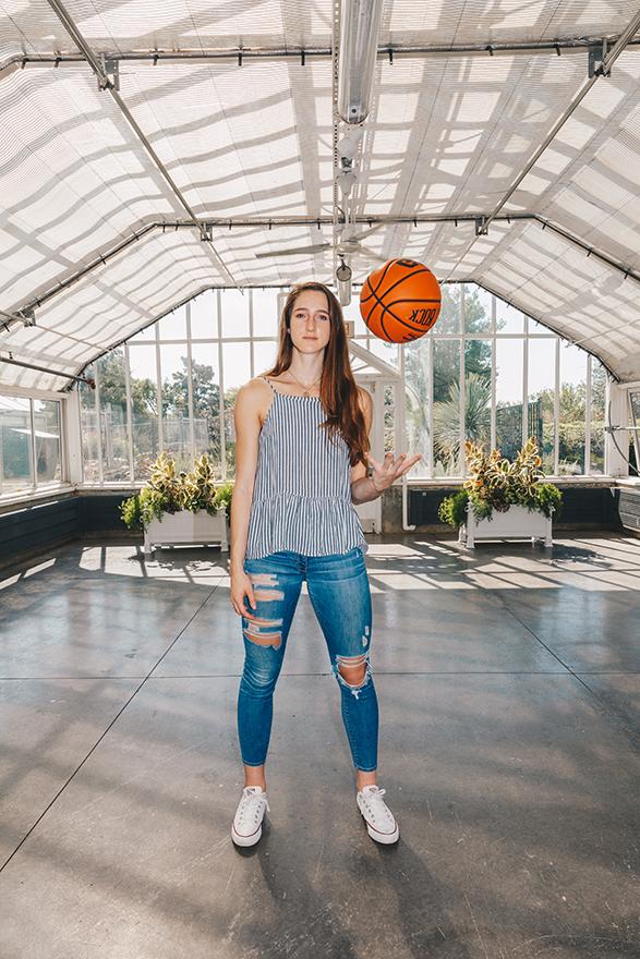 women's basketball player  throwing ball up in the air