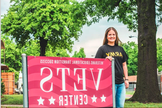 Veteran Student standing by VETS Center sign