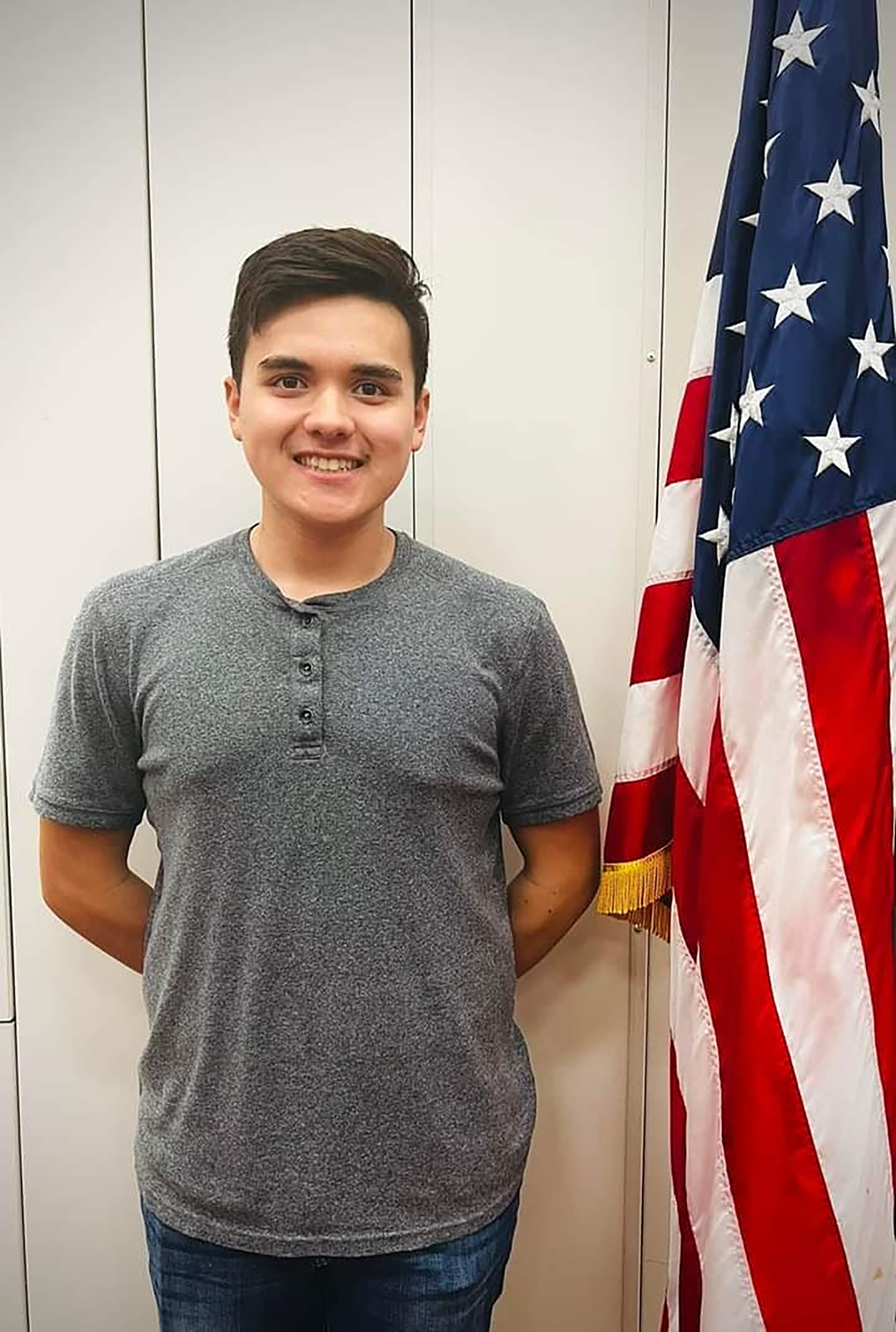 student standing by flag