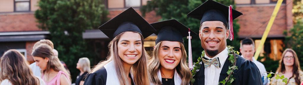 three SNU Graduates smiling in regalia