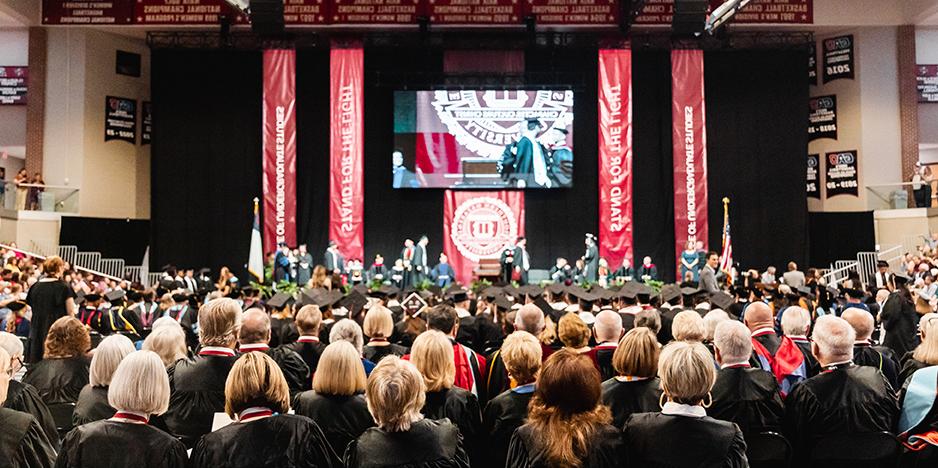 graduates sit at commencement 2024